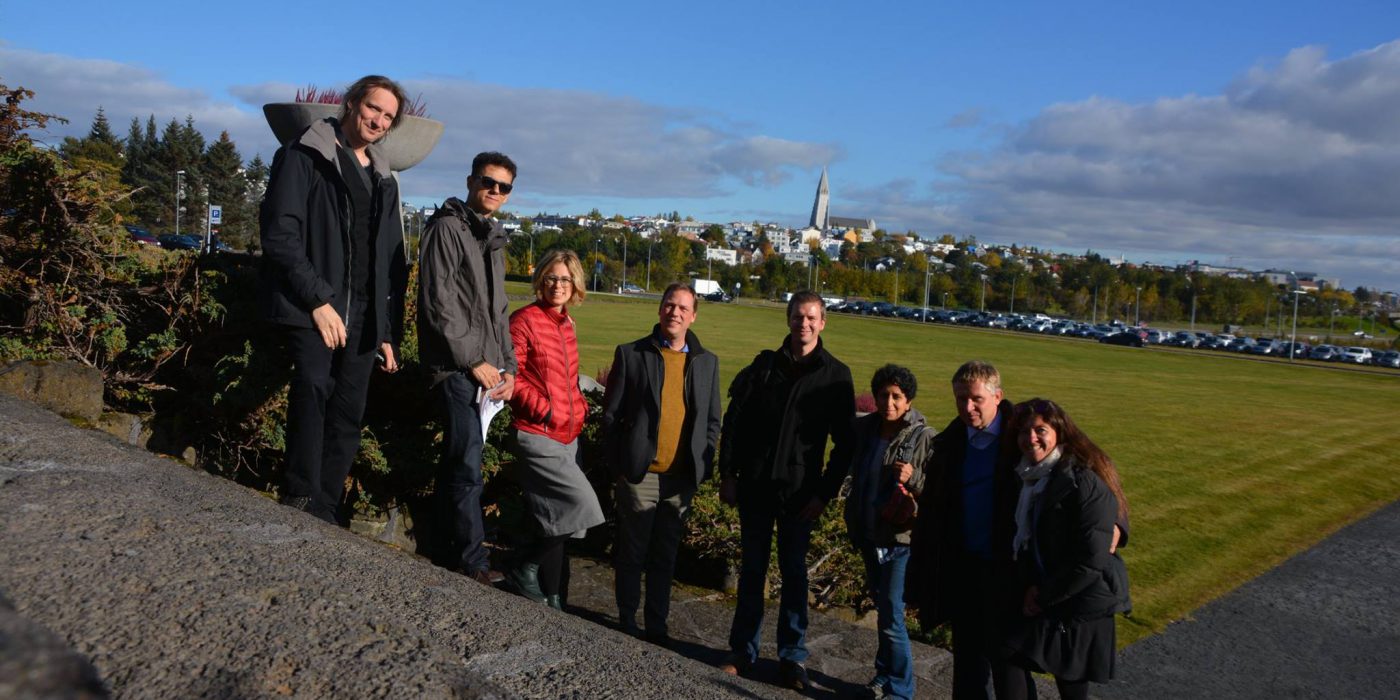 Grupa osób, w tym Martyna Rubinowska z Ashoki oraz Ashoka Fellow Adam Jagiełło-Rusiłowski, pozuje na tle panoramy miasta. Ubrani są jesiennie.