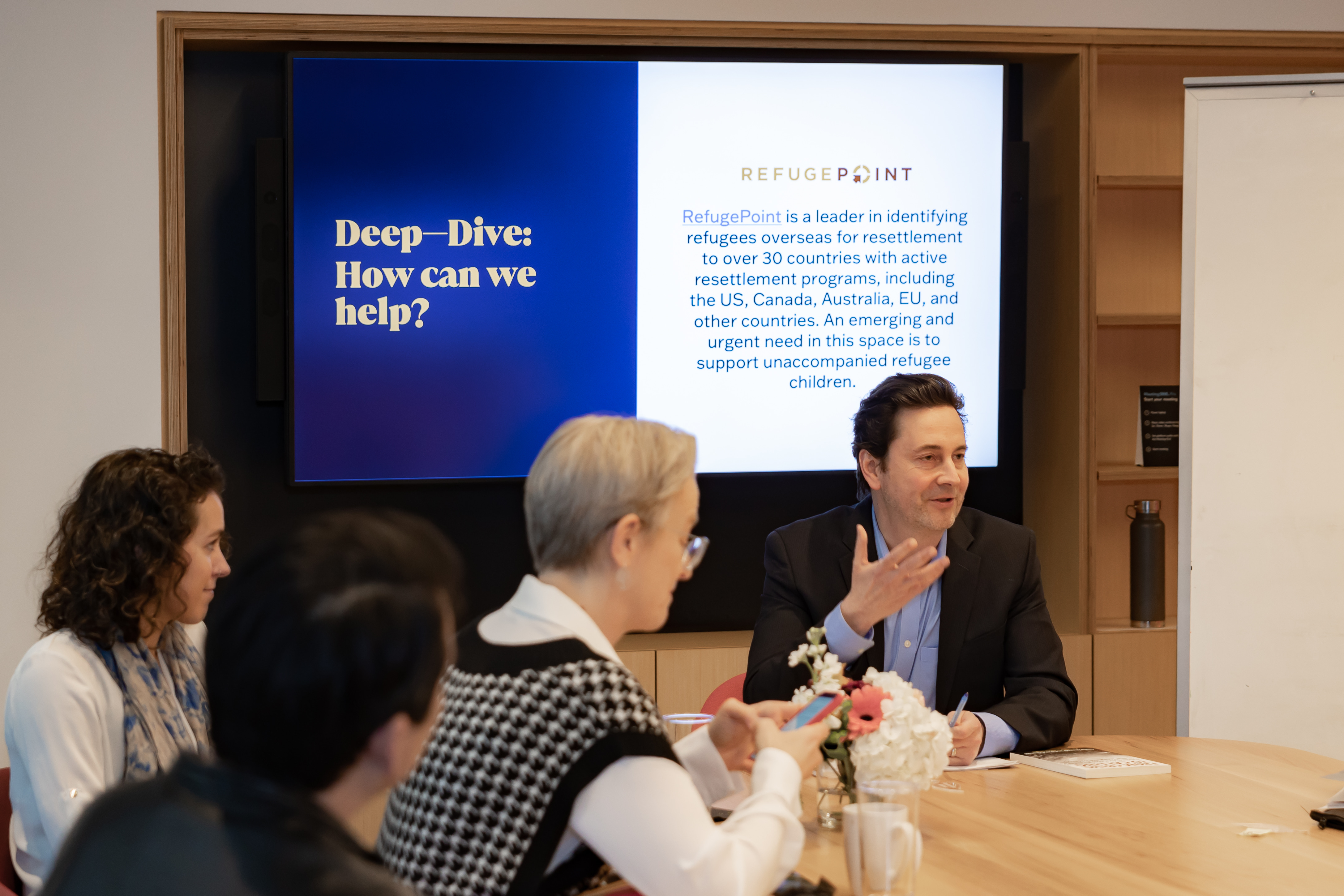 Sasha Chanoff presenting in front of a screen