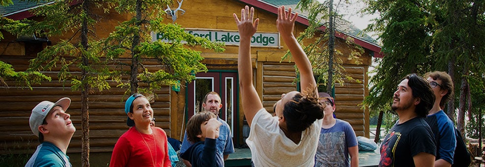 Group of people in a circle doing an activity at an outdoor camp