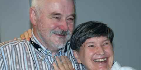 Two seniors, smiling and huging 