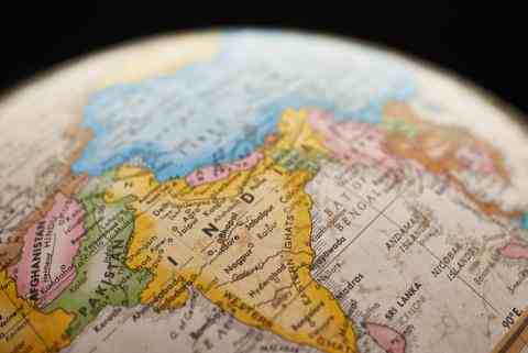 Photo of a globe that has India in the middle. Other countries in Asia all around it. Each of the countries are color coded