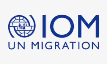 Logo of a world like icon. IOM UN Migration are the words next to the globe