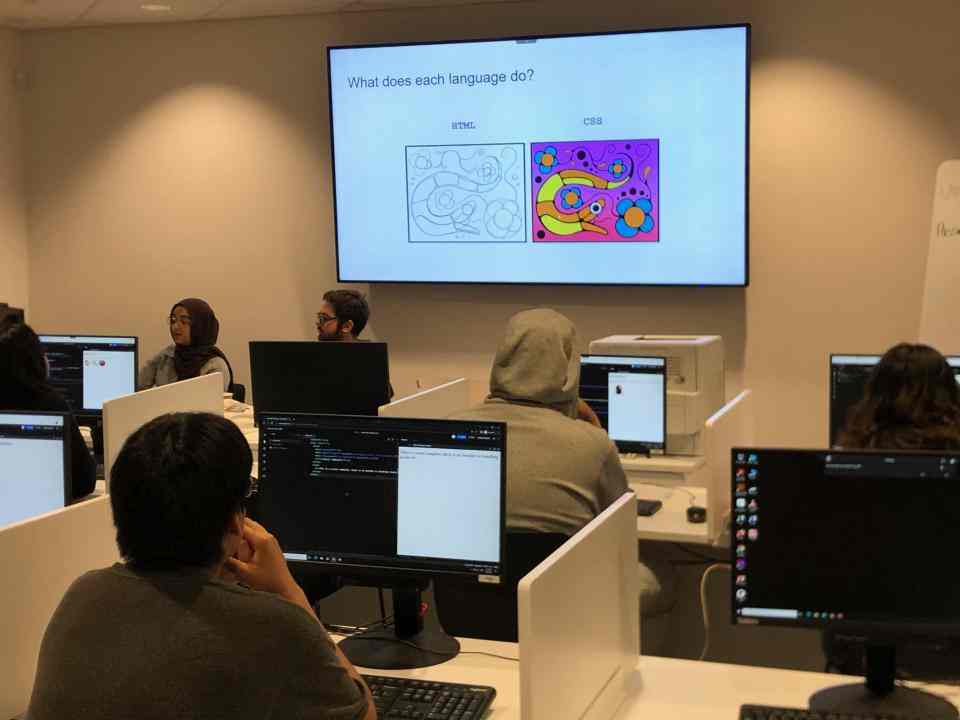 Young people in a classroom learning coding