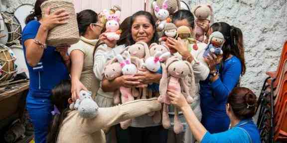 Zdjęcie grupy kobiet trzymających w pluszowe zabawki-króliki. Tylko jedna z nich patrzy w kamerę, reszta stoi wokół niej, ale ma odwrócone twarze.