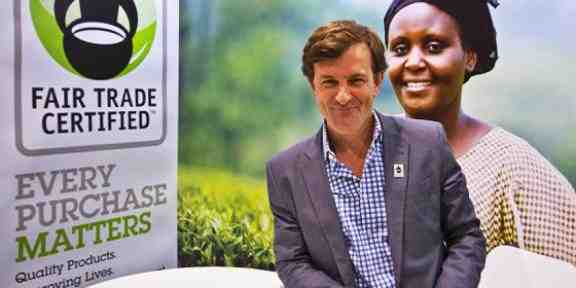 Zdjęcie uśmiechającego się Paula Rice. Po jego lewej baner z logo Fair Trade Certificate i podpisem "every purchase matters".
