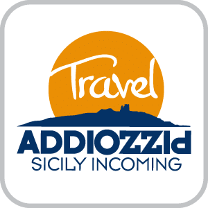 Logo for Addiopizzo travel, Ashoka Italy (Italia) Partner; Orange circle like a sun over a city in solid blue; in the orange circle is the word "Travel" in white. underneath the city is the word Addiopizzo in capital dark blue letters, where Addio is left to right, and then Pizzo is upside down going right to left, sharing the o with Addio; underneath in smaller capital letters: "Sicily incoming"