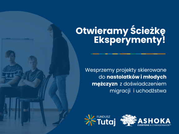 Na grantowym tle po lewej stronie biały napis "Otwieramy Ścieżkę Eksperymenty! Wesprzemy projekty skierowane do nastolatków i młodych mężczyzn z doświadczeniem migracji i uchodźstwa." Poniżej logo Funduszu Tutaj i logo Ashoki. Po prawej stronie grafiki zdjęcie przedstawiające 2 nastolatków siedzących na krzesłach i jednego nastolatka stojącego i opierającego się o krzesło.