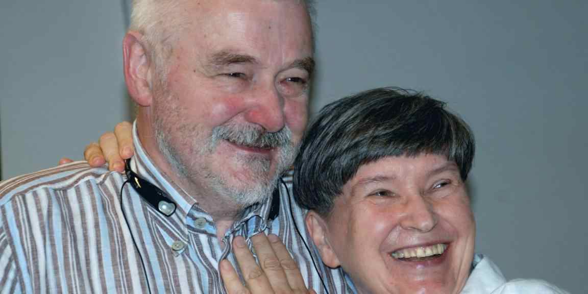 Two seniors, smiling and huging 