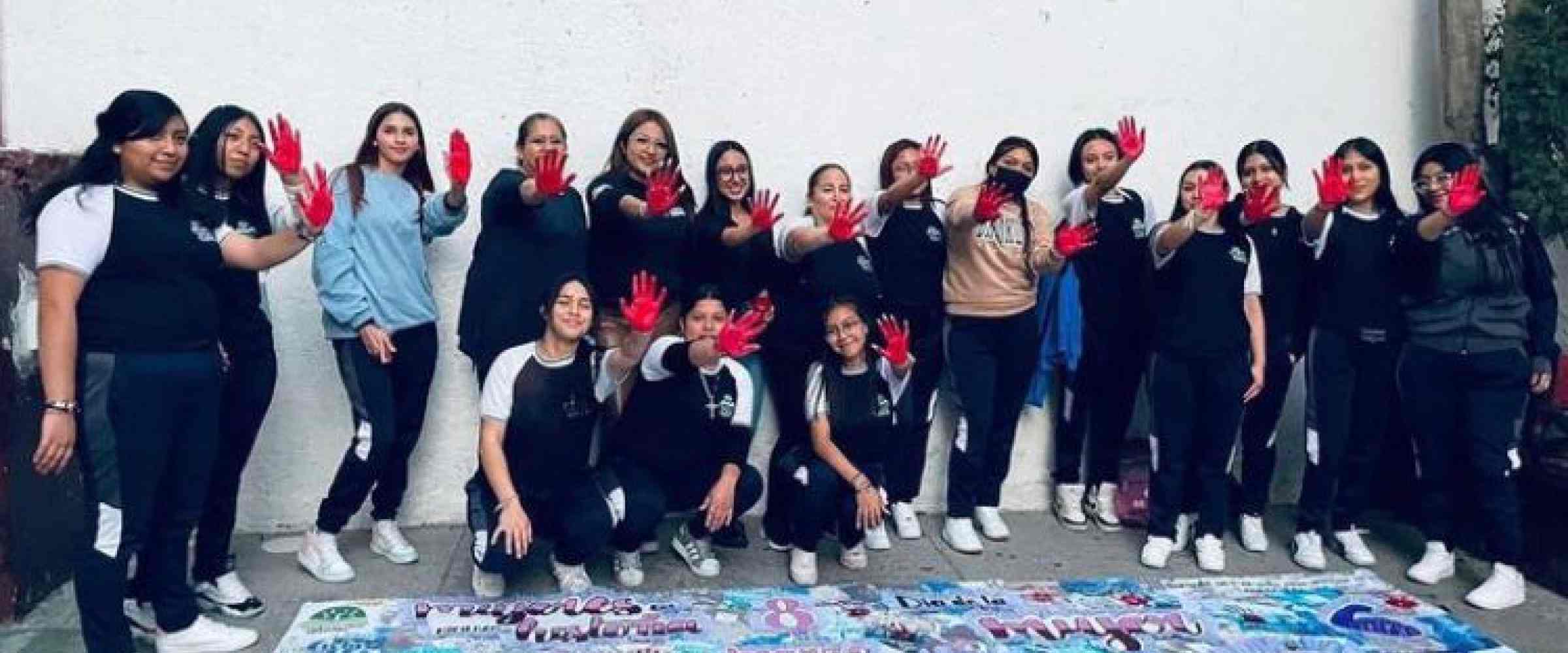 Grupo de estudiantes y maestras pintando un mural