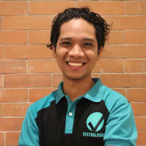 Ashoka Philippines Fellow Ryan Gersava smiles while wearing a collared shirt with the logo of his organization Virtualahan