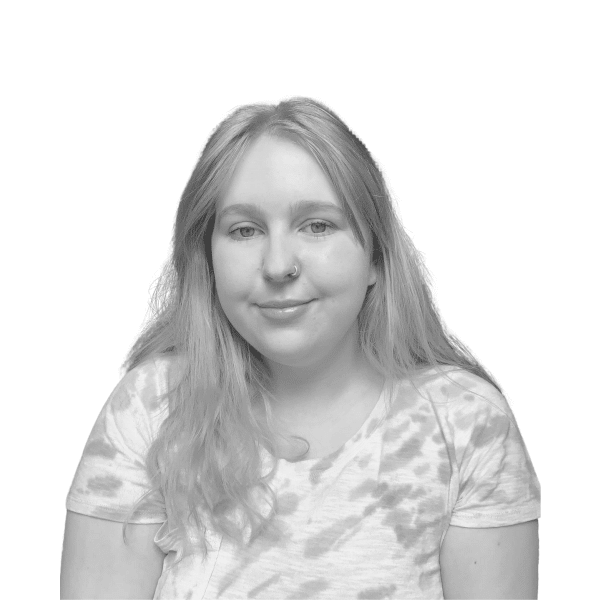 Photo of Charlotte Lastoweckyi, Ashoka UK Staff. Photo in black and white. Person with long light hair and lighter skin in a light T-shirt looking at the camera; white background behind the person