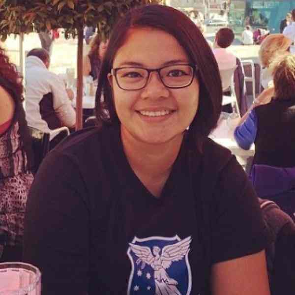 A woman with spectacles smiling. 