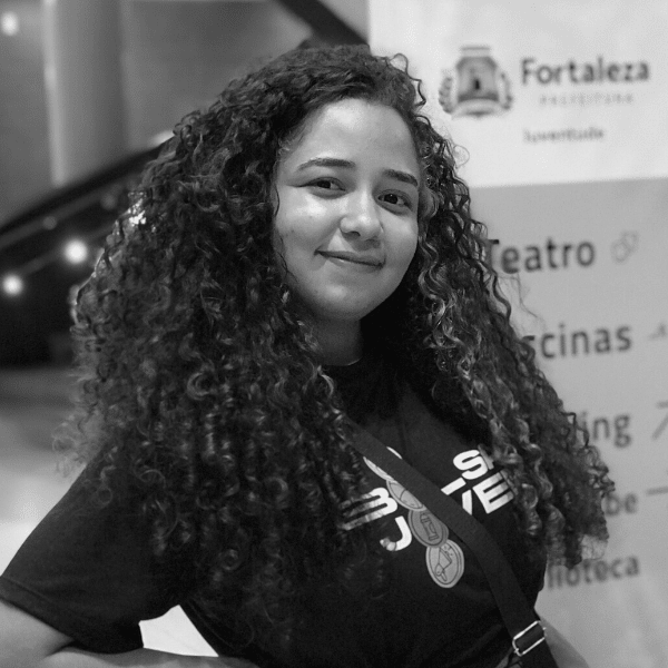 Foto em preto e branco de Sabrina, jovem de cabelos longos e cacheados