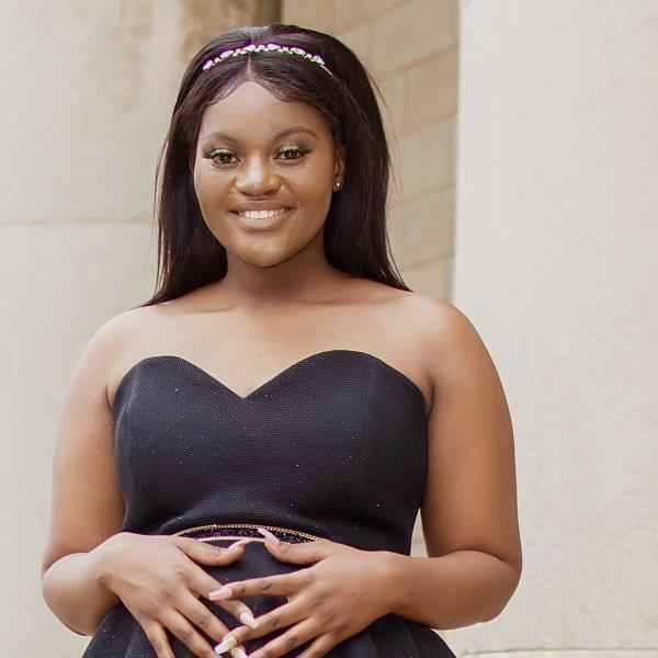 Photo of Nqobile Mabasa, Ashoka Africa staff. Person with long black hair and darker skin smiling at the camera. Dressed in a black blouse