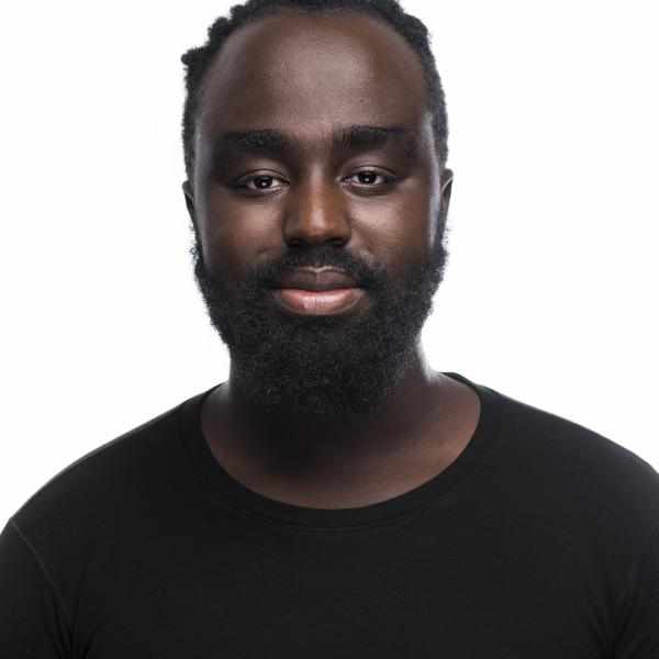Okong'o in a black shirt with a beard on a white background