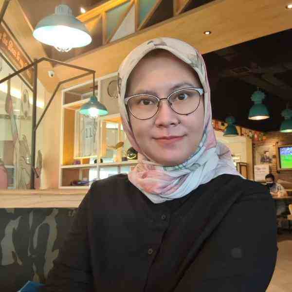 Picture of a woman wearing a pink headscarf and glasses