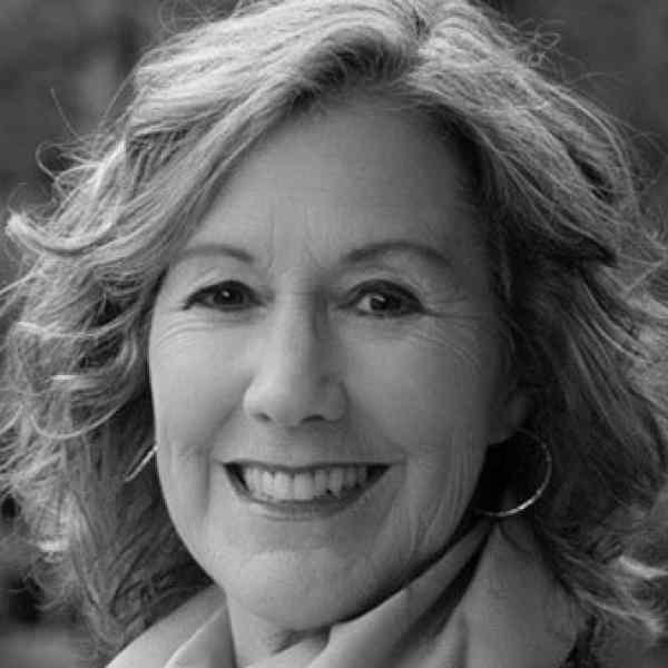 Black and white headshot of Nancy Mortifee, ASN member in Canada. Person with light shoulder length hair smiling at the camera. Background outdoors