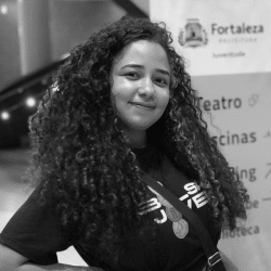 Foto em preto e branco de Sabrina, jovem de cabelos longos e cacheados