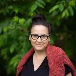 A woman posing in front of a forest