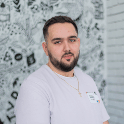Young man with a beard wearing white t-shirt standing inside
