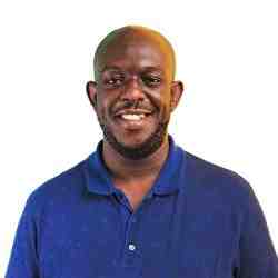 Al smiling in a blue shirt on a white background