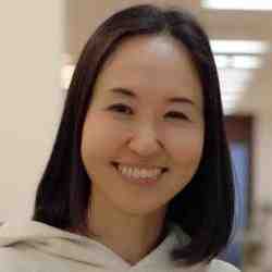 Picture of a Japanese woman with short, dark hair. She is smiling at the camera
