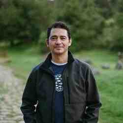 Picture of a man with dark hair wearing a black jacket