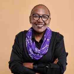 Photo of Ashoka Fellow Grace Matlhape. She is a black woman with short hair wearing glasses and a purple scarf.