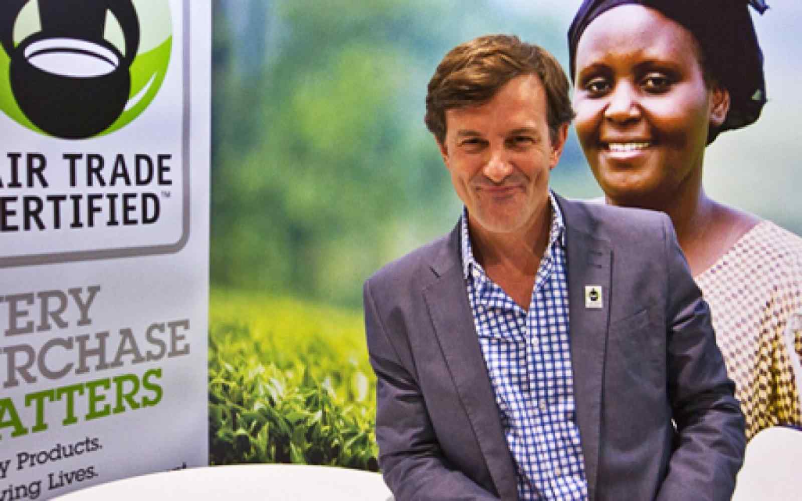 Zdjęcie uśmiechającego się Paula Rice. Po jego lewej baner z logo Fair Trade Certificate i podpisem "every purchase matters".