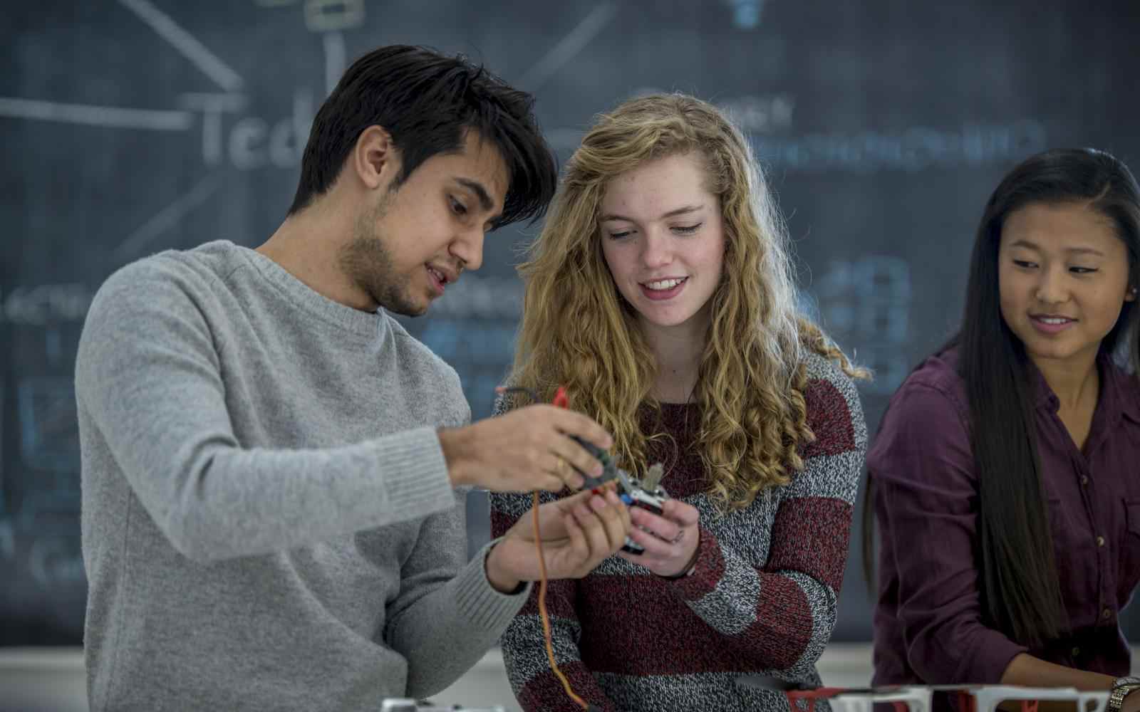 Two teens work together on a robotics project in science class