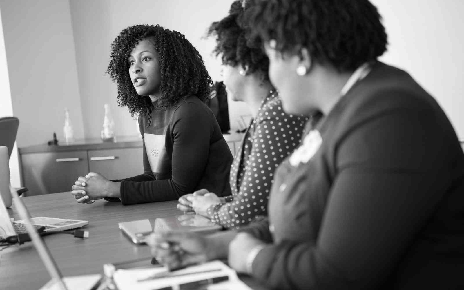 Three young leaders meet around a conference table