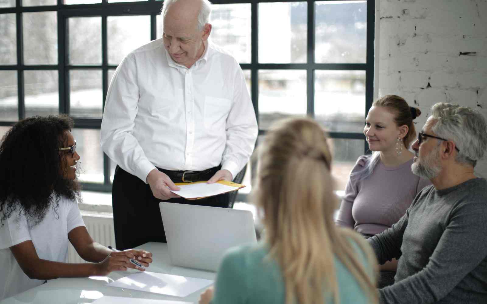 Smiling multiethnic coworkers discussing project in office