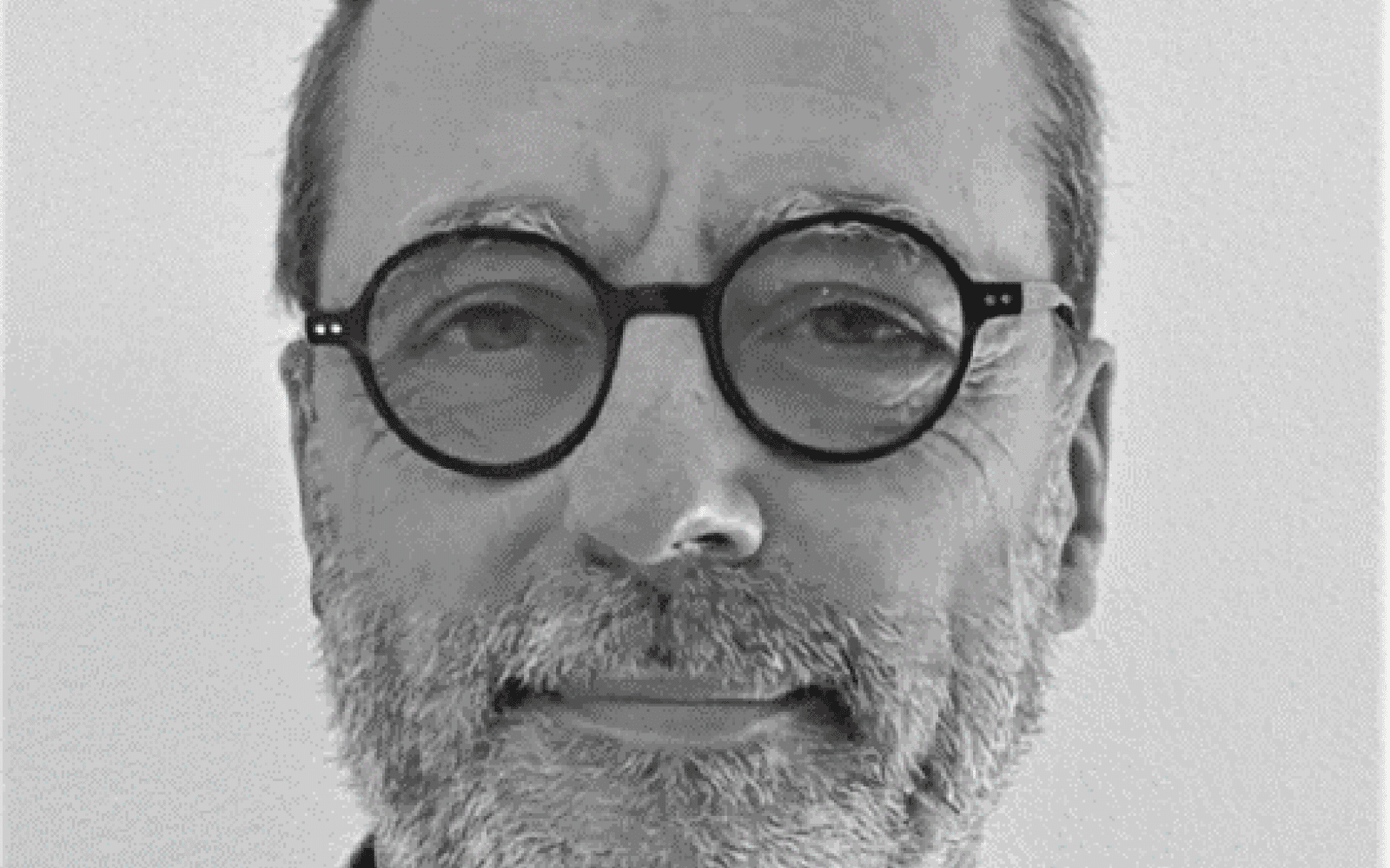 photo de Pierre De Rauglaude - cheveux coupés ras, barge grise et lunettes rondes et noires