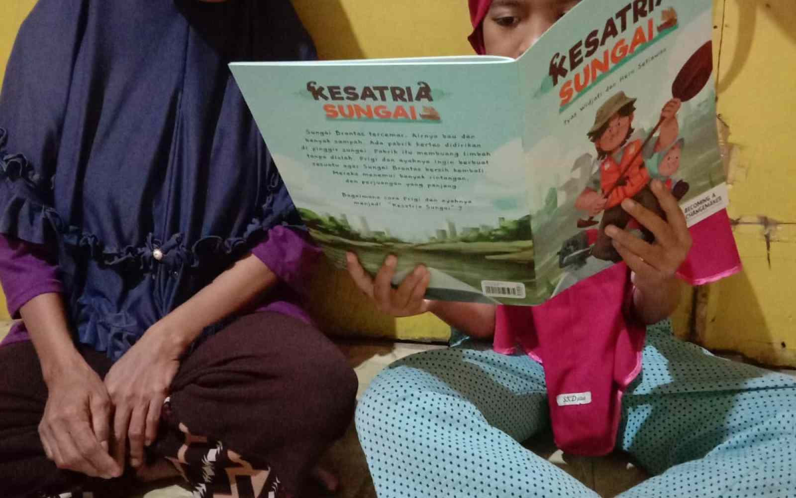 A little girl read changemaking book with her grandmother 