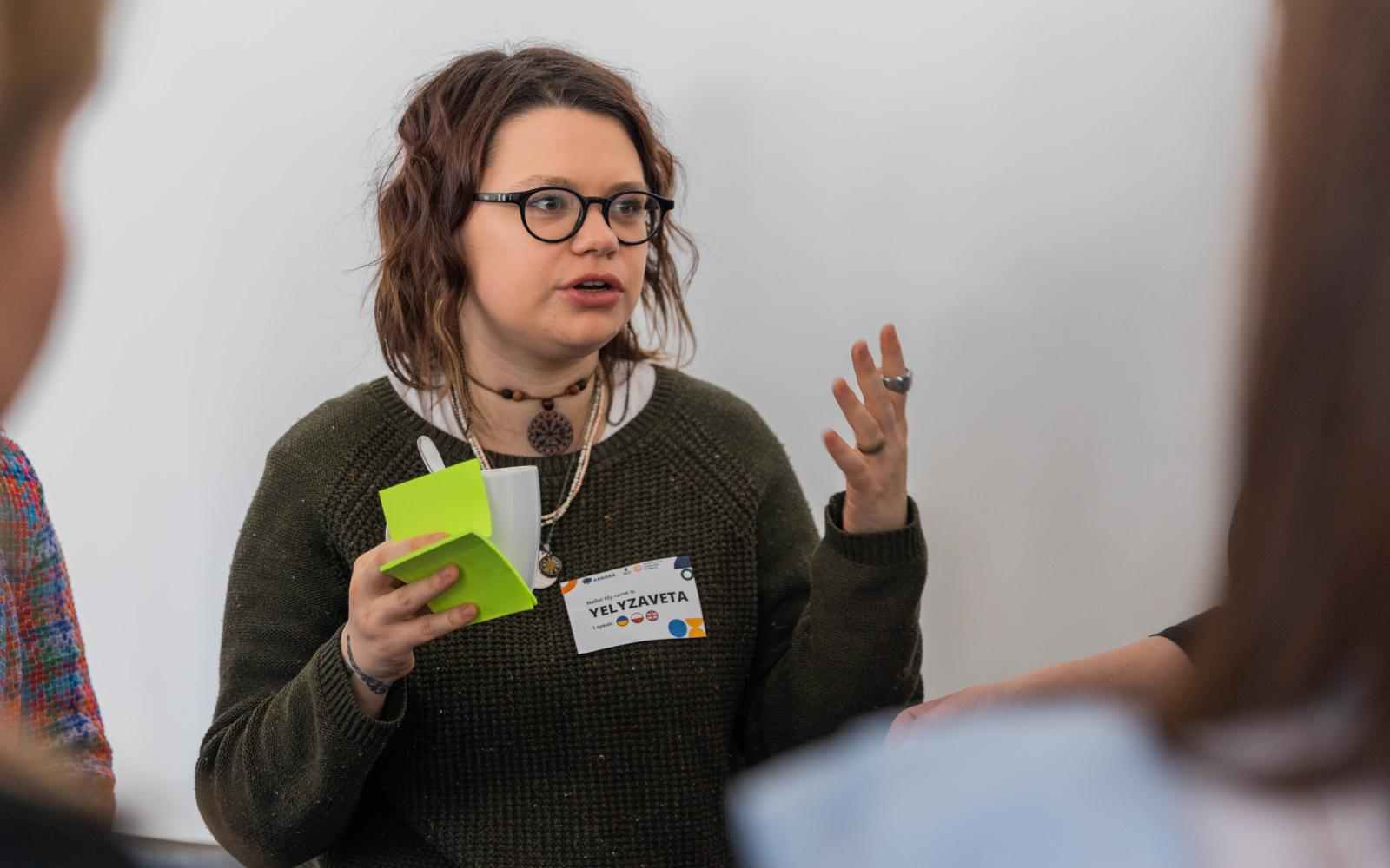 A girl holding post-its in one hand and talking