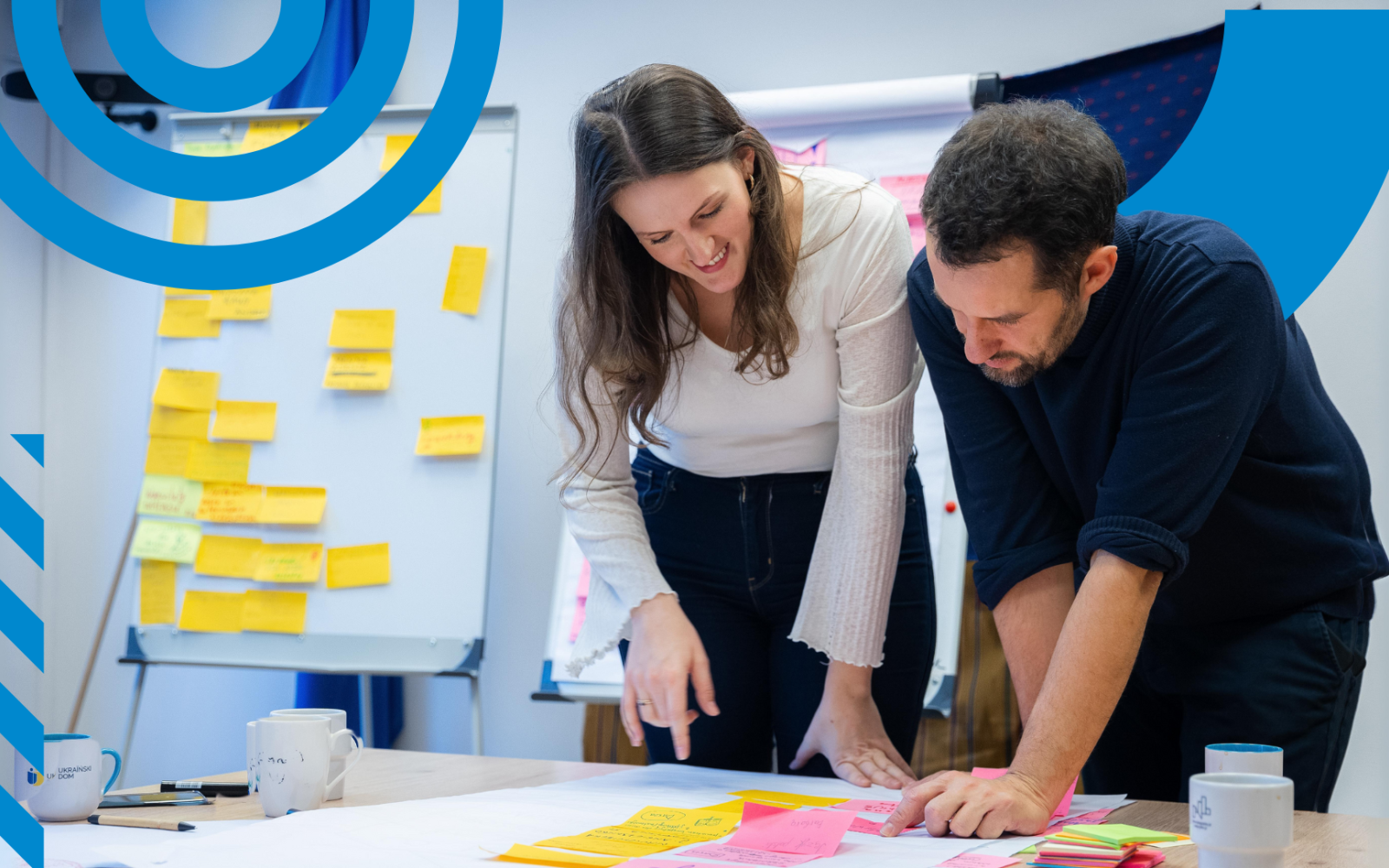Young woman and man looking at post-its on the desk