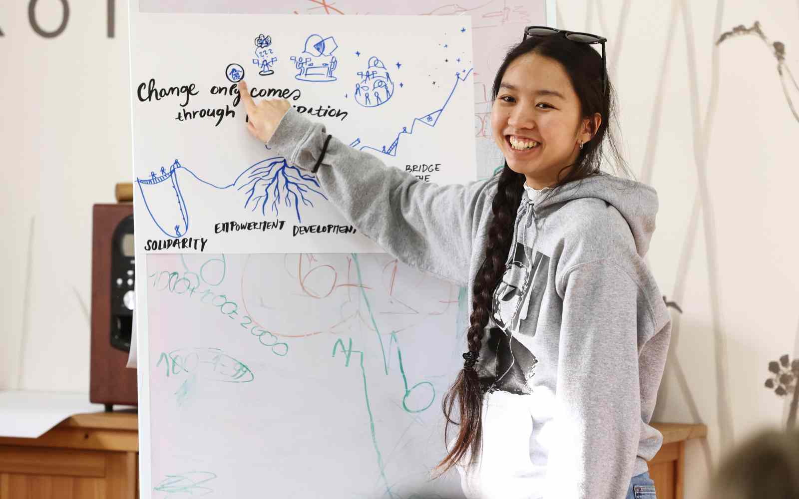 Young woman presenting something on the board, smiling