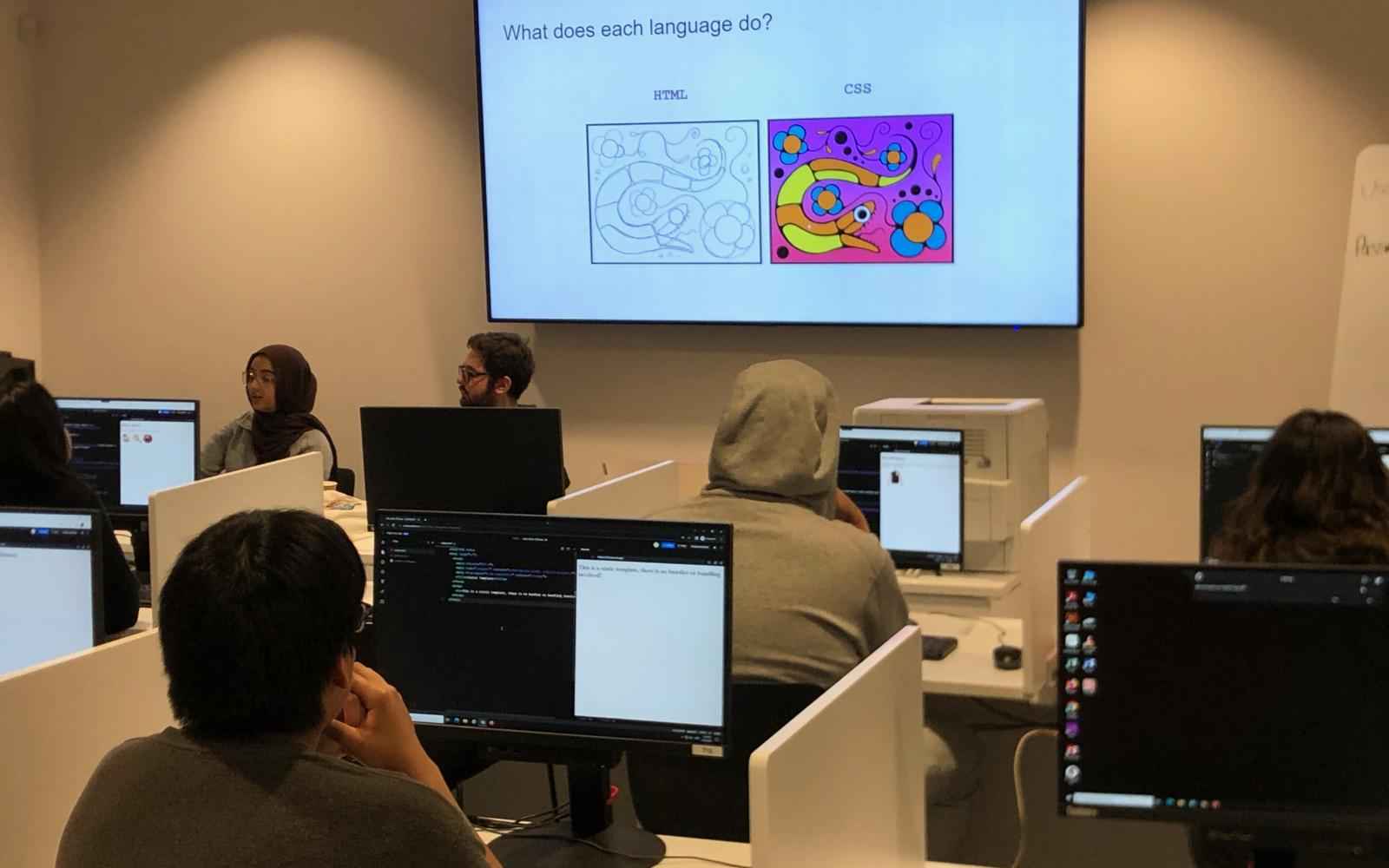 Young people in a classroom learning coding