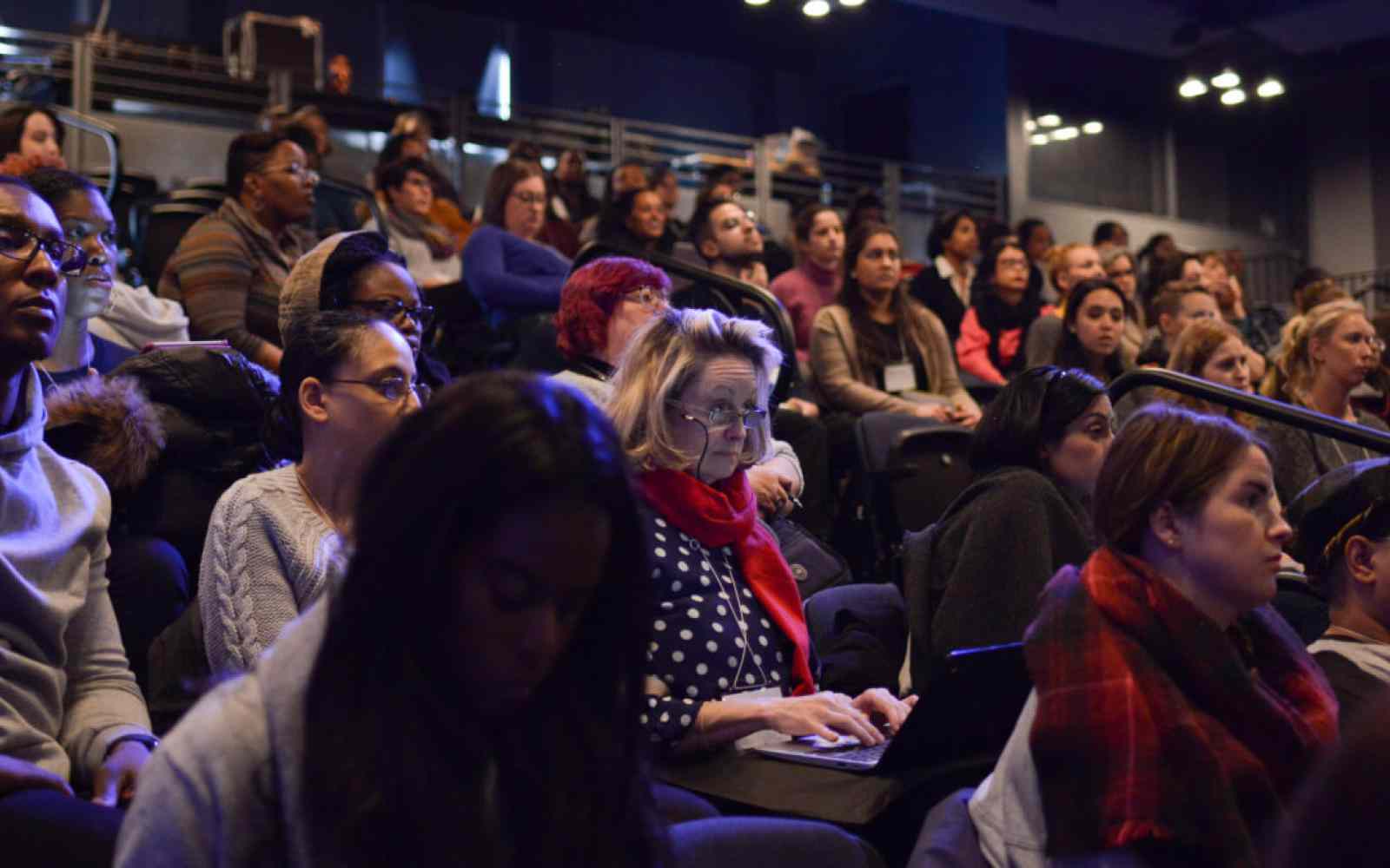 Photo of an audience seated in an indoor auditorium