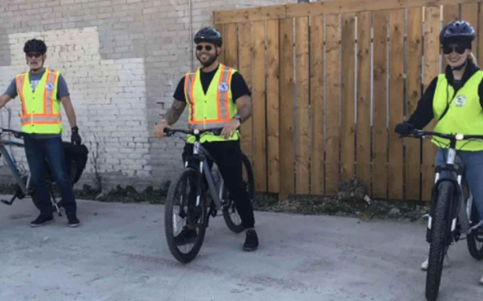 Three people part of the Bear Claw Patrol sitting on bikes