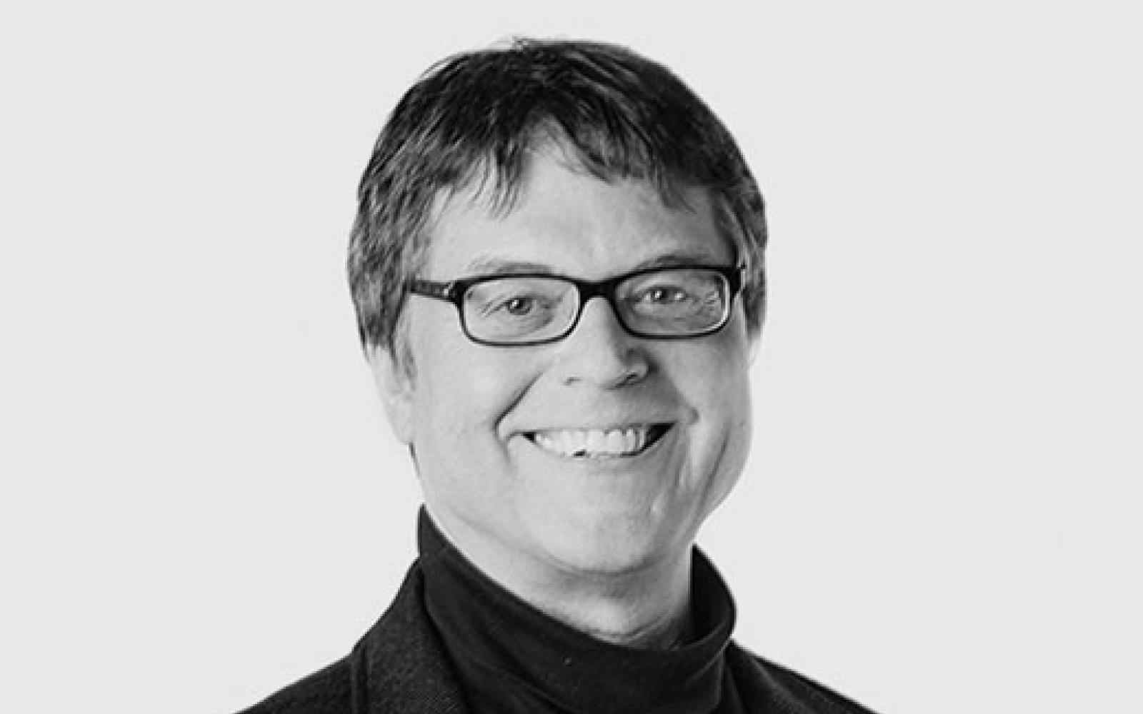 Black and white headshot of Canada Fellow Brent Kopperson. Person with short hair and glasses smiling at the camera