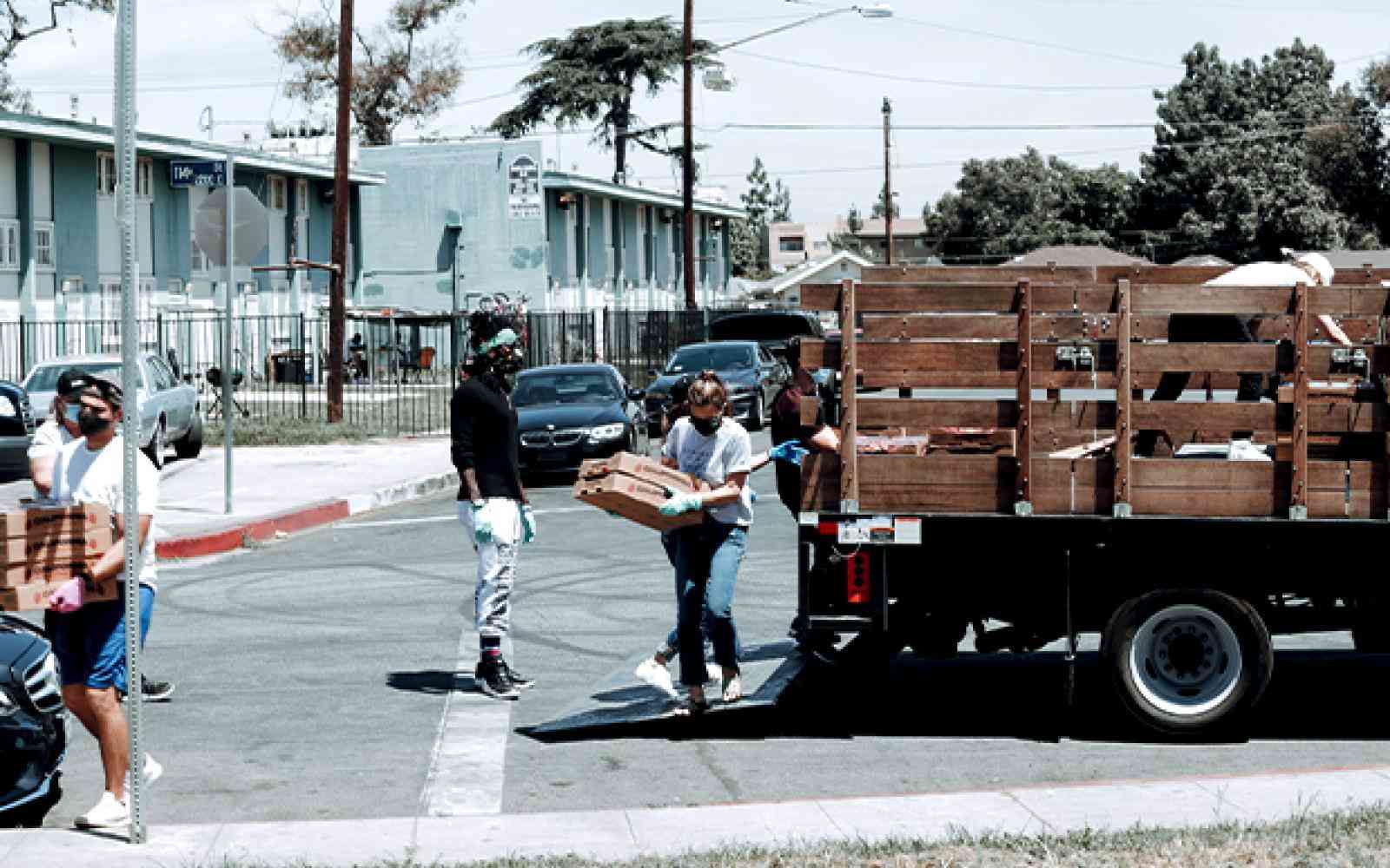 Two people unloading donated food with masks on