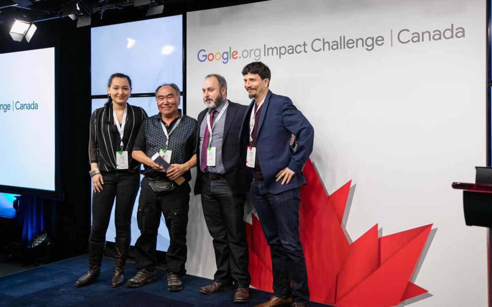 Photo of four members of SIKU team in front of Google Imapact Challenge banner