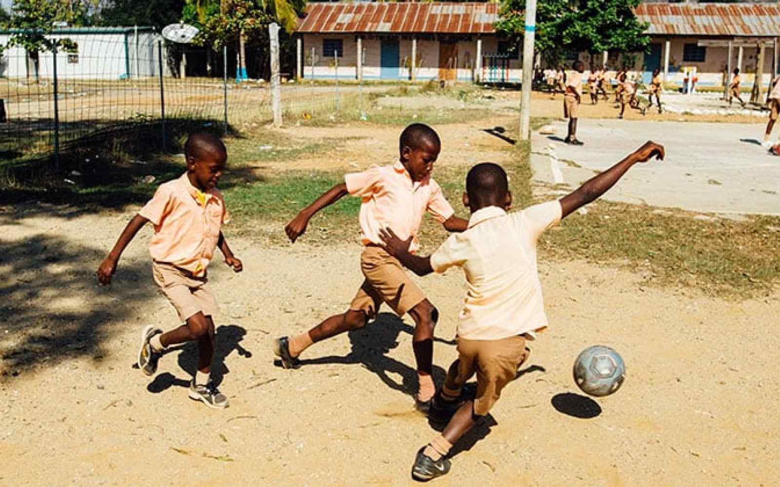 Children playing soccer in a playground
