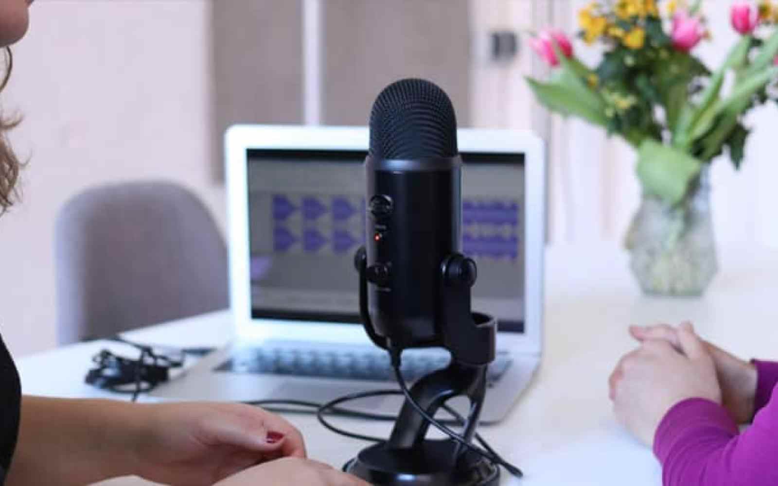 Photo of a microphone with two people off camera nearby