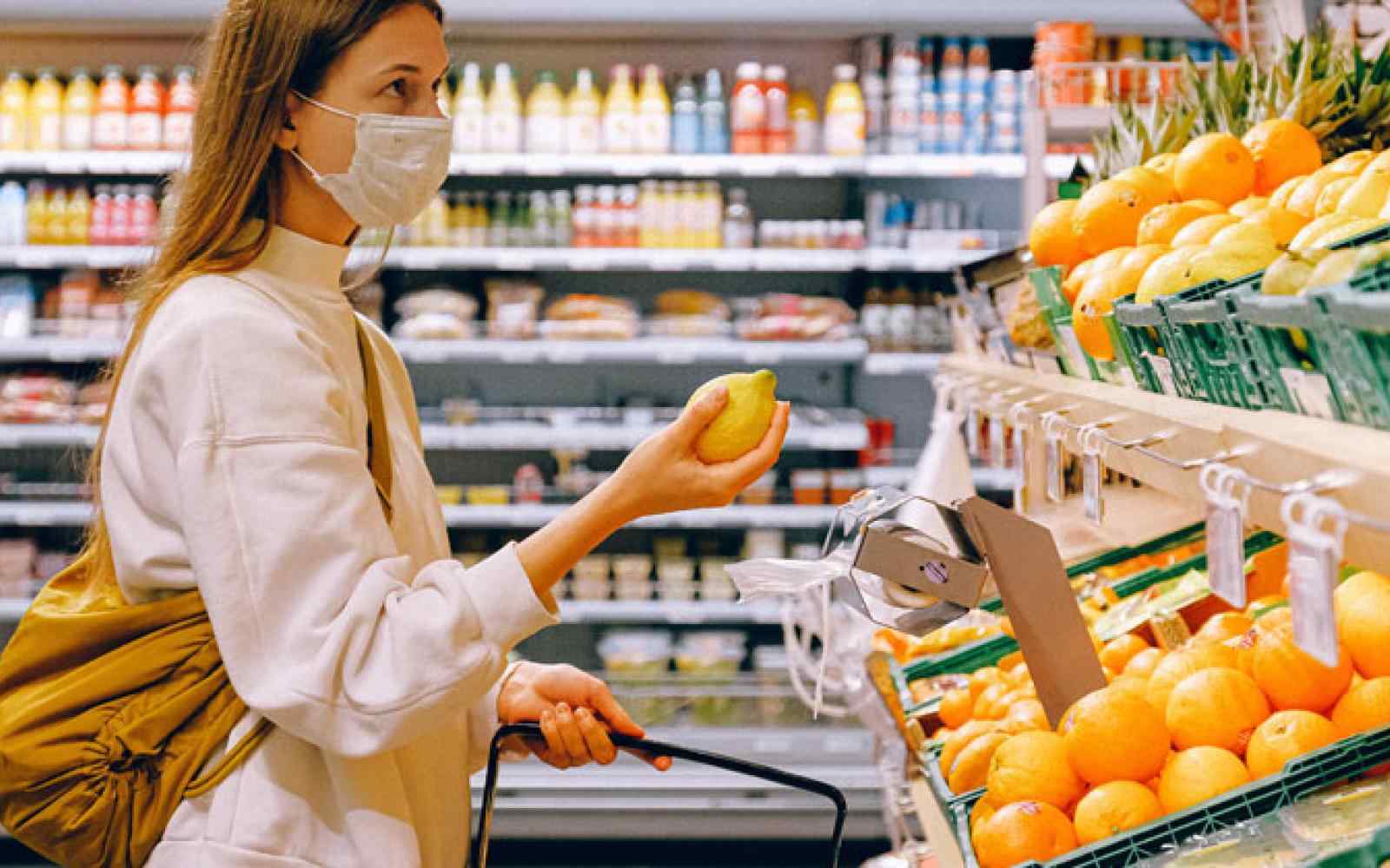 Person shopping in the produce section with a mask on