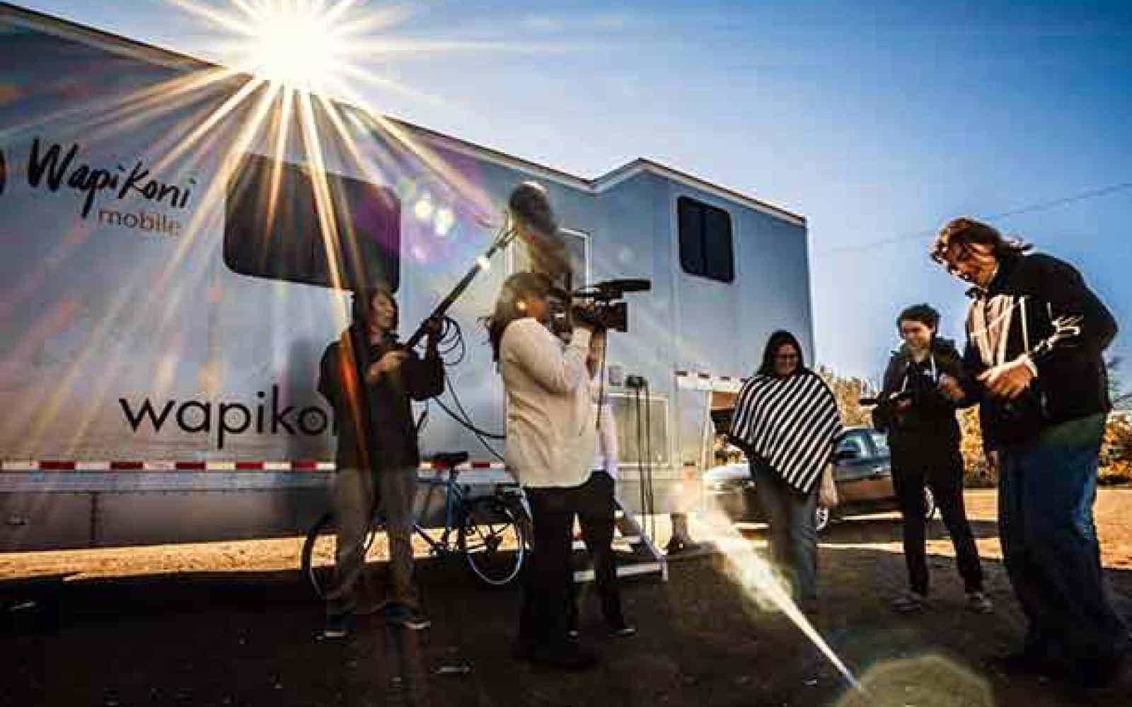 Group of people shooting a film in front of a Wapikoni mobile truck