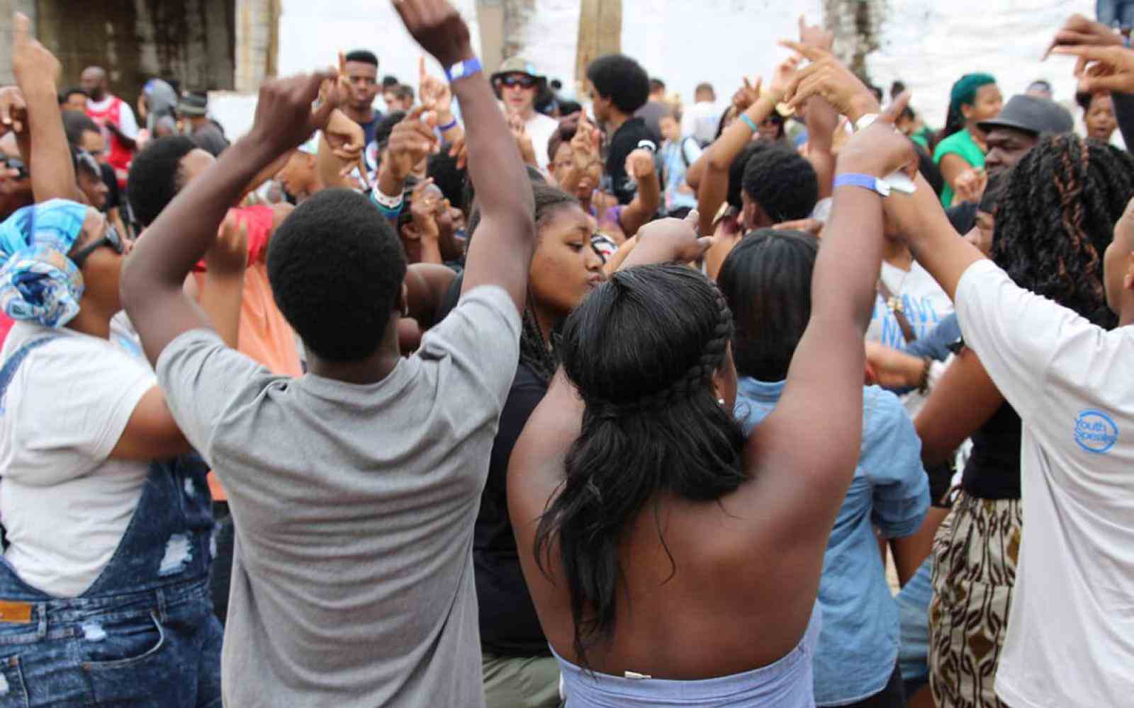 Photo of a group of youth jumping with arms up in a courtyard