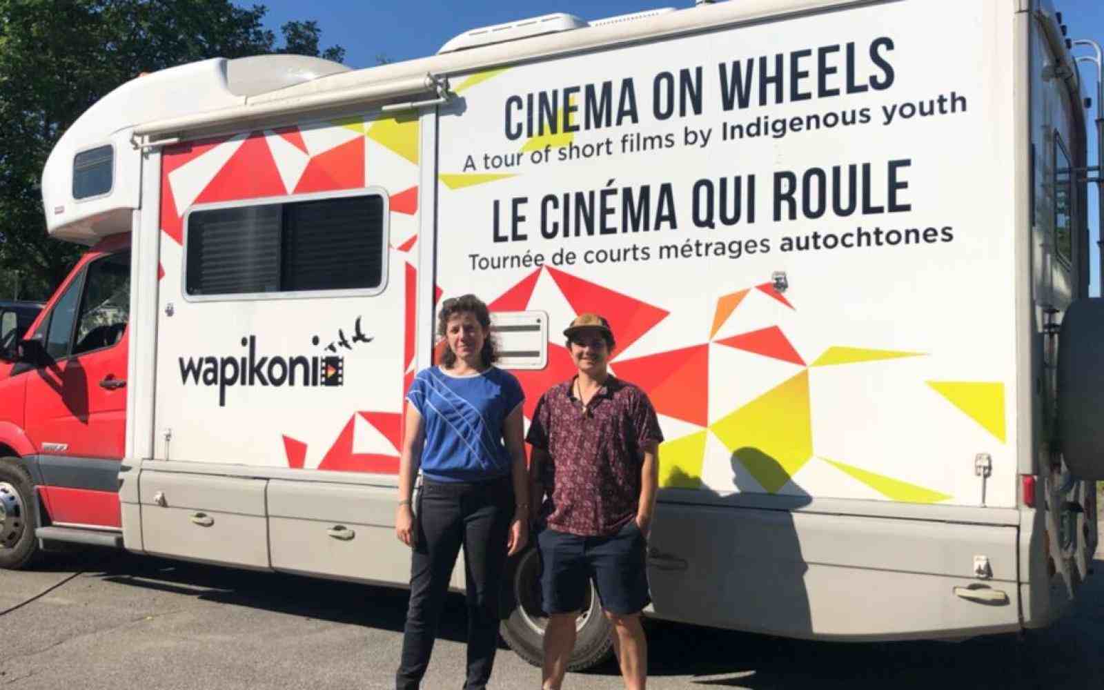 Two indigenous filmmakers in front of a truck with Wapikoni on the side