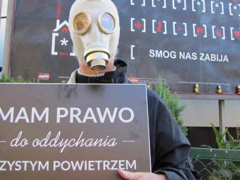 a person in a gas mask with a banner: I have a breath to breathe clean air